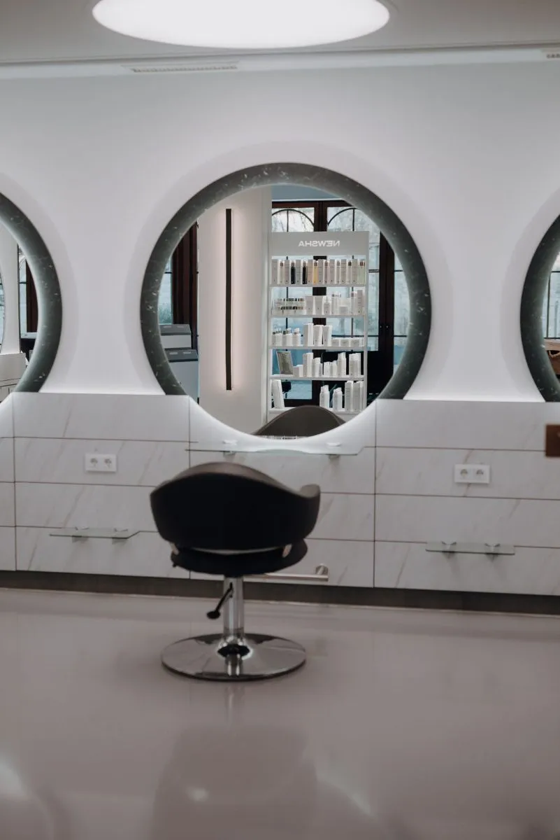 Stuhl vor rundem Spiegel im Premium Salon Nauen